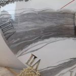 ساعت دیواری گرد با طرح ابر و باد در رنگ‌های سفید و طوسی و نقره‌ای